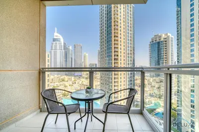 a balcony with a table and chairs and a view of the city at Glamorous 1BR at Residences 5 Downtown Dubai by Deluxe Holiday Homes in Dubai