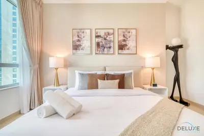 a bedroom with a large white bed with two lamps at Glamorous 1BR at Residences 5 Downtown Dubai by Deluxe Holiday Homes in Dubai