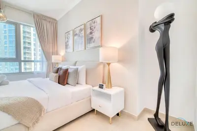 a bedroom with a white bed and a black lamp at Glamorous 1BR at Residences 5 Downtown Dubai by Deluxe Holiday Homes in Dubai