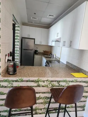 a kitchen with two chairs and a counter top at Upgraded 1 Bhk Silicon Oasis Short or long rental in Dubai