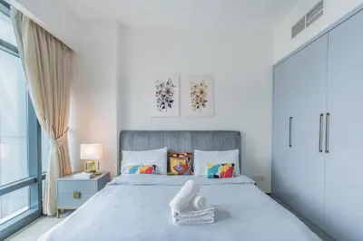 a white bedroom with a large bed and a window at Scenic lake view 2BR near metro in Cluster A, JLT - Allsopp&Allsopp in Dubai