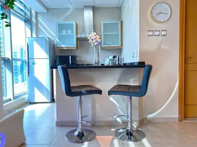 a kitchen with a counter with two bar stools at Elegant Studio in Dubai Marina Near Beach and Metro Z1013 in Dubai