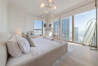 a bedroom with a large bed and a large window at EDEN'S Homes & Villas - Boulevard Point in Dubai