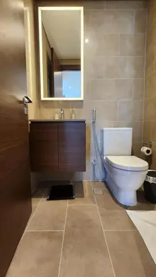 a bathroom with a toilet and a sink and a mirror at STAY BY LATINEM Luxury 1BR Holiday Home CVR A2609 near Burj Khalifa in Dubai