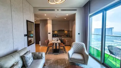 a living room with a couch and a table with chairs at STAY BY LATINEM Luxury 1BR Holiday Home CVR A2609 near Burj Khalifa in Dubai