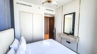 a bedroom with a white bed and a mirror at STAY BY LATINEM Luxury 1BR Holiday Home CVR A2609 near Burj Khalifa in Dubai