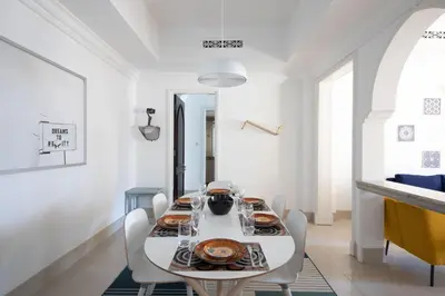 a white dining room with a white table and chairs at Chic 2BR with Burj Khalifa View in Souk Al Bahar in Dubai
