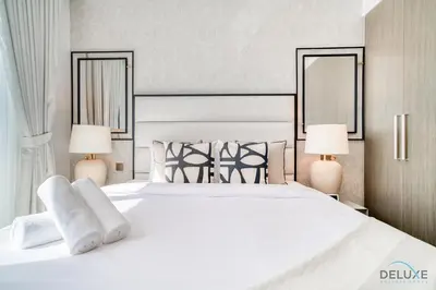 a bedroom with a large white bed with two lamps at Captivating 1BR at 17 Icon Bay Dubai Creek Harbour by Deluxe Holiday Homes in Dubai