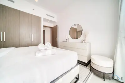 a white bedroom with a bed and a mirror at Captivating 1BR at 17 Icon Bay Dubai Creek Harbour by Deluxe Holiday Homes in Dubai