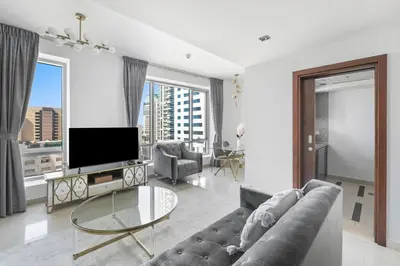 a living room with a couch and a tv at StoneTree - Park Island Blakely 1 BR - Prime location in Dubai