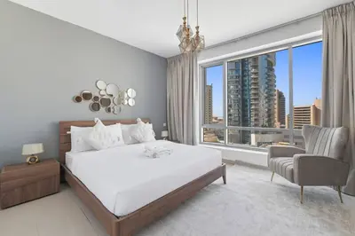 a bedroom with a white bed and a large window at StoneTree - Park Island Blakely 1 BR - Prime location in Dubai