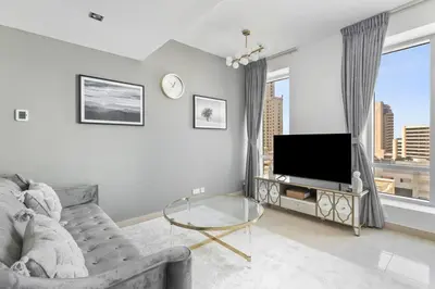 a living room with a couch and a tv at StoneTree - Park Island Blakely 1 BR - Prime location in Dubai