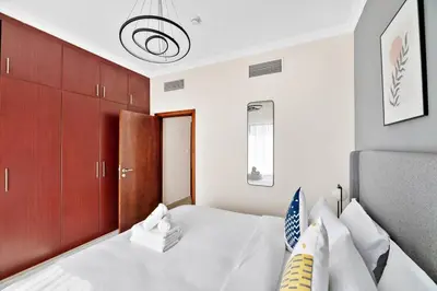 a bedroom with a white bed and red cabinets at StoneTree - Time Place Tower 1 BR - Amazing View in Dubai