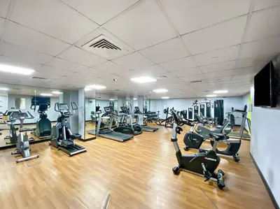 a gym with several treadmills and cardio machines at StoneTree - Time Place Tower 1 BR - Amazing View in Dubai