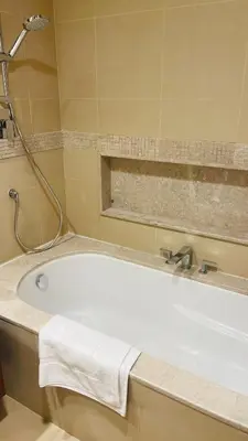 a bath tub in a bathroom with a shower at AMAKIN Burj Vista Tower 1 in Dubai