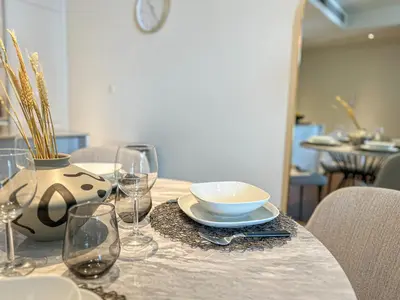 a table with a bowl and wine glasses on it at HiGuests - Charming Retreat in CityWalk With Balcony and Pool in Dubai