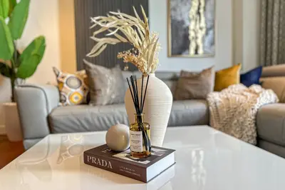 a living room with a table with a vase on it at HiGuests - Charming Retreat in CityWalk With Balcony and Pool in Dubai