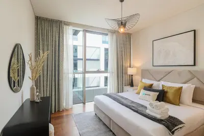a bedroom with a large bed and a large window at HiGuests - Charming Retreat in CityWalk With Balcony and Pool in Dubai