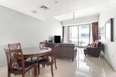 a dining room and living room with a table and chairs at StoneTree - Ocean Heights 1 BR - High Floor in Dubai