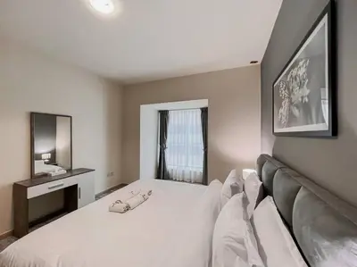 a bedroom with a large white bed and a mirror at StoneTree - Elite Residence 1 BR - Near Dubai Tram in Dubai
