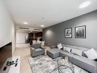 a living room with a couch and a table at StoneTree - Elite Residence 1 BR - Near Dubai Tram in Dubai