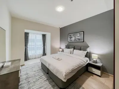 a bedroom with a large bed and a large window at StoneTree - Elite Residence 1 BR - Near Dubai Tram in Dubai