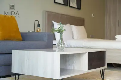 a living room with a table with a vase on it at Mira Holiday Homes - Fully furnished Studio in Business Bay in Dubai