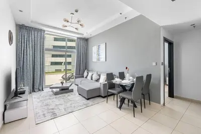 a living room with a table and a couch at StoneTree - SkyView Tower 1 BR - Best Location in Dubai