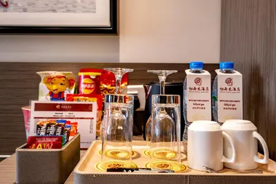 a tray with bottles and glasses on a table at Peony Hotel in Dubai