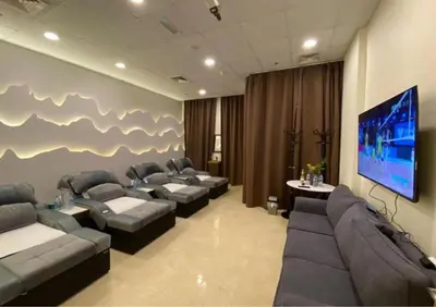 a waiting room with couches and a flat screen tv at Peony Hotel in Dubai