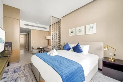 a bedroom with a large bed with a blue blanket at ALiving Elegant Studio with Balcony I Canal View I DAMAC Maison Prive- 706B in Dubai