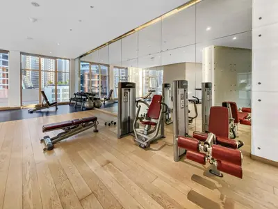 a gym with several exercise equipment and a mirror at ALiving Elegant Studio with Balcony I Canal View I DAMAC Maison Prive- 706B in Dubai