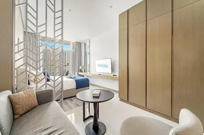a room with a bed and a couch and a table at ALiving Elegant Studio with Balcony I Canal View I DAMAC Maison Prive- 706B in Dubai