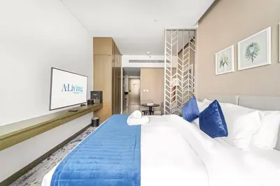 a hotel room with a large bed with blue pillows at ALiving Elegant Studio with Balcony I Canal View I DAMAC Maison Prive- 706B in Dubai