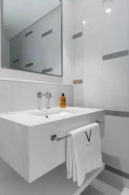a white bathroom with a sink and a mirror at Sea View with Private Beach Access! 3BR & Maid Rm in Dubai