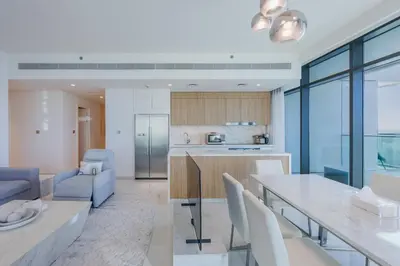 a kitchen and living room with a table and chairs at Sea View with Private Beach Access! 3BR & Maid Rm in Dubai