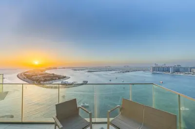 a balcony with two chairs and a view of the ocean at Sea View with Private Beach Access! 3BR & Maid Rm in Dubai