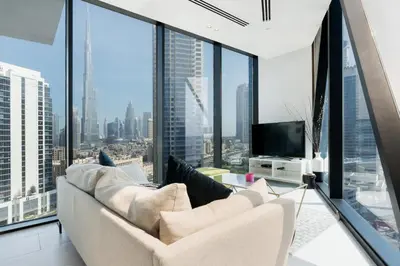 a living room with a couch and large windows at Marquise Square - 2Br Apartment - Allsopp&Allsopp in Dubai