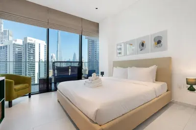 a bedroom with a large bed and a large window at Marquise Square - 2Br Apartment - Allsopp&Allsopp in Dubai