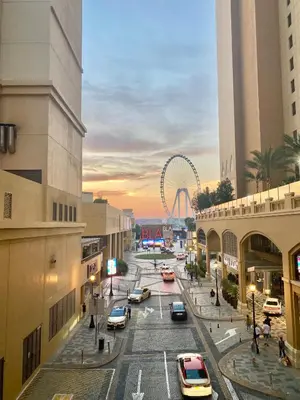a city street with a ferris wheel in the background at JBR Beach - Panoramic Sea View 2BR Apartment in Dubai