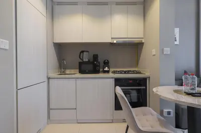 a kitchen with white cabinets and a table and chairs at Business Bay 1 bedroom with Canal view in Dubai