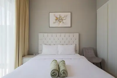 a bedroom with a white bed with two pairs of slippers on it at Business Bay 1 bedroom with Canal view in Dubai