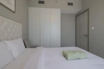 a bedroom with a white bed with a towel on it at Business Bay 1 bedroom with Canal view in Dubai