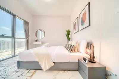 a white bedroom with a bed and a mirror at Classic 1BR at MAG 510 Dubai South by Deluxe Holiday Homes in Dubai