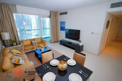 a living room with a dining table and a living room with a couch at Alashrafia Saray - Spectacular 2BR in Canal Views in Dubai