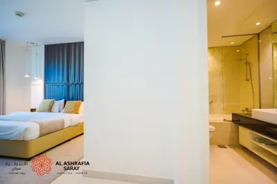 a bedroom with a bed and a shower and a bathroom at Alashrafia Saray - Spectacular 2BR in Canal Views in Dubai
