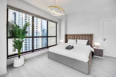 a bedroom with a large bed and a large window at JBR 3 bedroom apartment with fantastic ocean view in Dubai