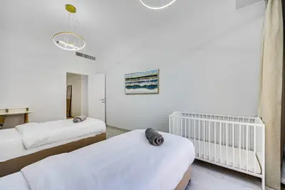 a bedroom with two twin beds and a crib at JBR 3 bedroom apartment with fantastic ocean view in Dubai
