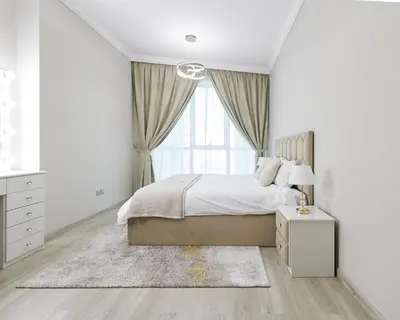 a white bedroom with a large bed and a window at 1 bedroom in Torch Tower Dubai Marina in Dubai