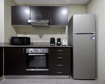 a kitchen with a refrigerator and a microwave at 1 bedroom in Torch Tower Dubai Marina in Dubai